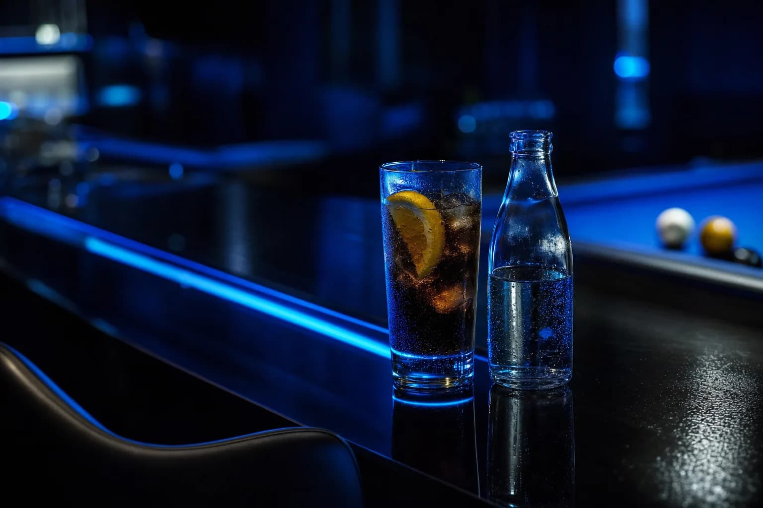 Un verre de cola avec des glaçons et une rondelle de citron sur le comptoir